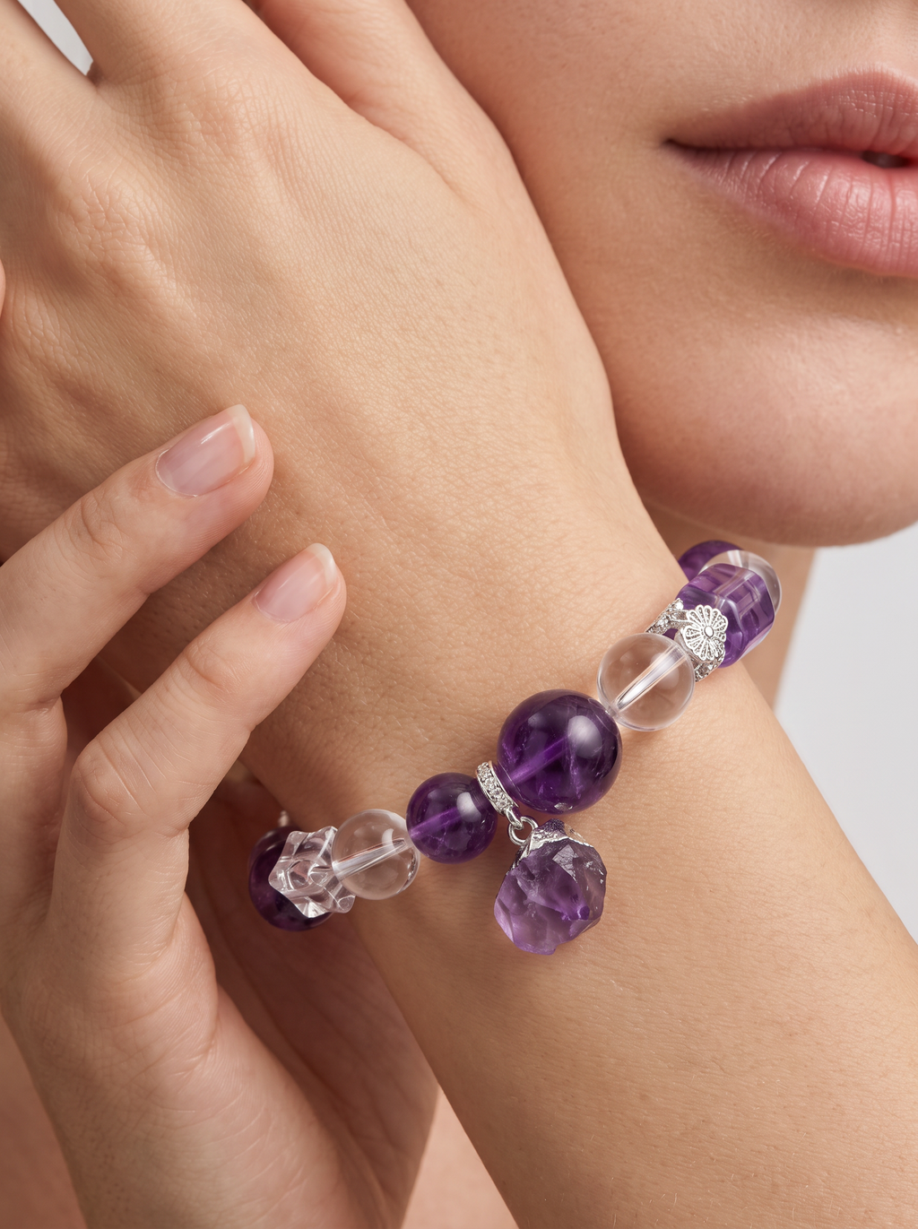 Model wearing an amethyst crystal bracelet with natural gemstone beads and pendant